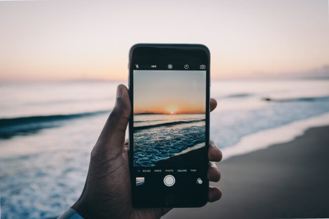 An iPhone taking a picture at a beach