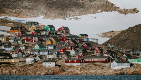 Ittoqqortoormiit settlement in eastern Greenland, with colourful houses scattered across the coast