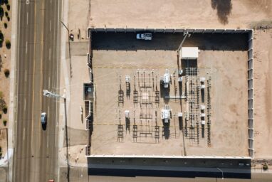 Aerial view of a data centre facility with rows of equipment beside a road