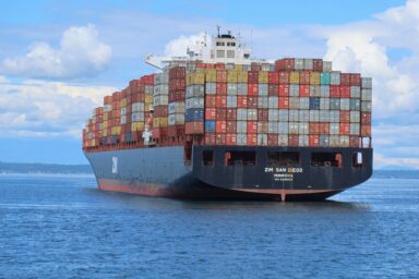 Container ship loaded with stacked shipping containers at sea