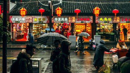 Shanghai street lined with colourful shop signs and traditional Chinese lanterns