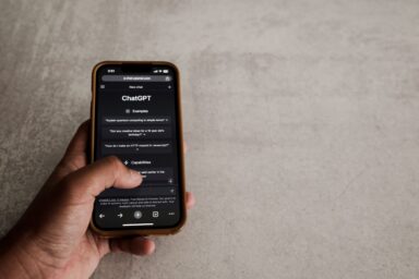 A hand holding a smartphone with the ChatGPT app open