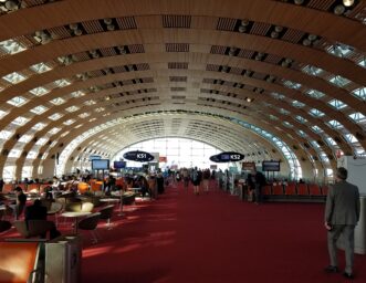 Passengers waiting at gates K51 and K52 under the arched roof of Paris Charles de Gaulle Airport