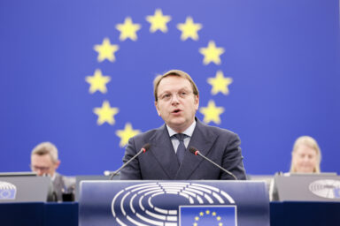 Health Commissioner Olivér Várhelyi speaks at a podium in the European Parliament in Strasbourg, with the EU flag behind him