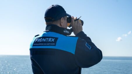 Frontex officer looking through binoculars