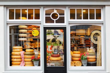 Shop window displaying stacked wheels of cheese