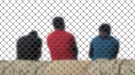 Migrants behind a fence