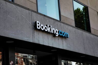 Booking.com logo on the grey stone façade of an office building