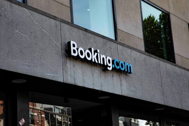 Booking.com logo on the grey stone façade of an office building