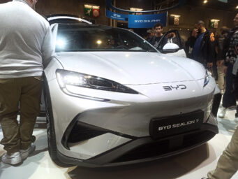 Visitors crowd around a silver BYD Sealion 7 electric SUV at a motor show