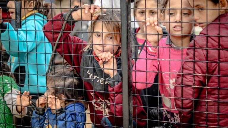 Children refugees behind a fence