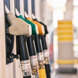 A row of fuel nozzles in different colours at a petrol station pump