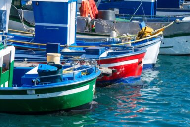 Colourful small fishing boats moored side by side in a harbour